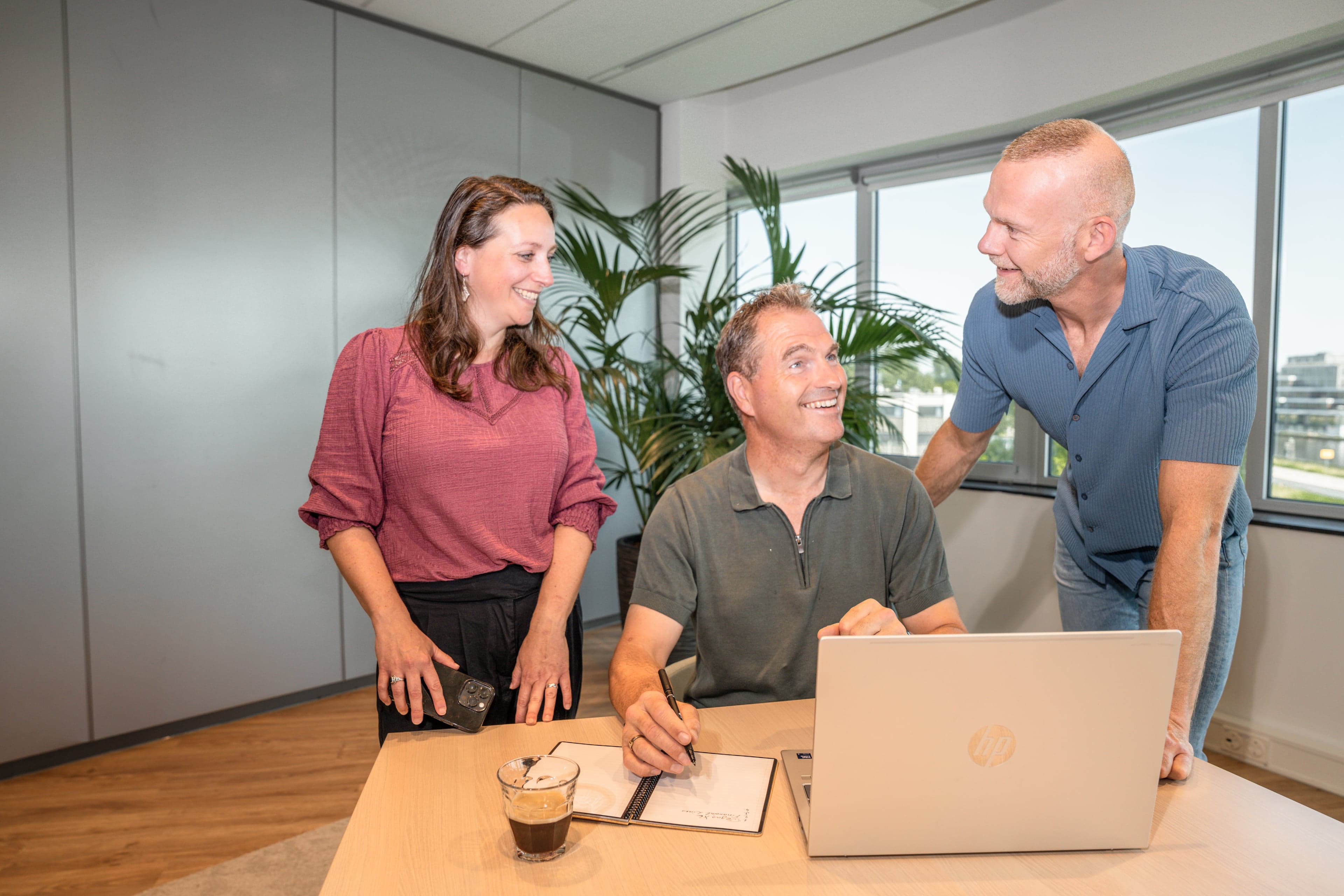 Drie collega's in overleg bij een laptop