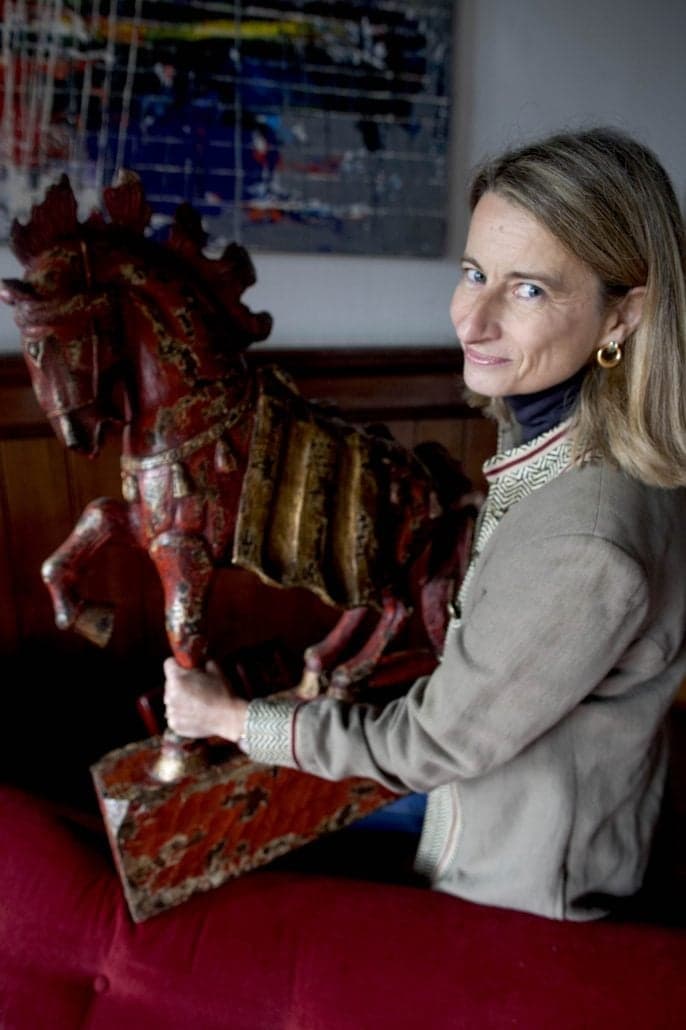 Vrouw houdt een antiek paardenbeeld vast